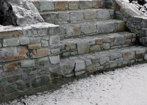 Kamenná zeď v zahradě se schodištěm